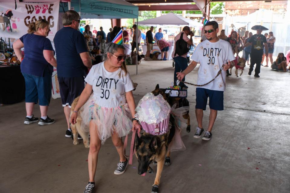 Two children sit with their dogs Sunday at the 30th annual Muttfest at the Starlight Ranch Event Center in Amarillo.