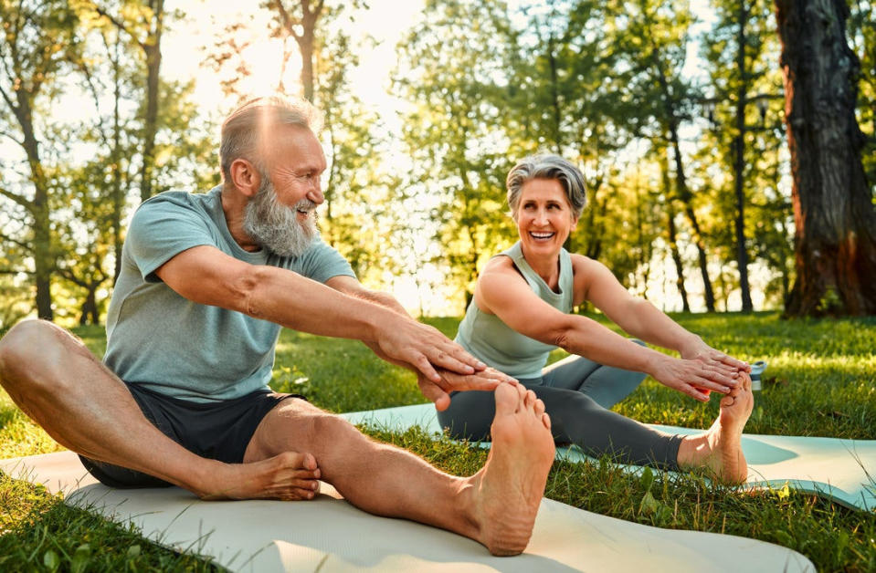 Two people stretching outdoors.