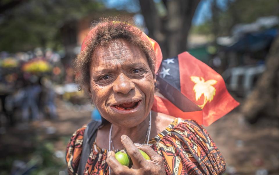 Judi David enjoys a betel nut at a market in Port Moresby