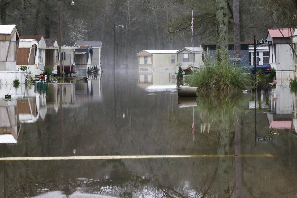 Standing floodwater from the Pearl River still surrounds a number of mobile homes in the back portion of the Harbor Pines community in Ridgeland, Miss., Tuesday, Feb. 18, 2020. Some residents are allowed temporary permission to enter their homes in the non-flooded portion of the mobile home community to retrieve clothing and prescriptions. (AP Photo/Rogelio V. Solis)