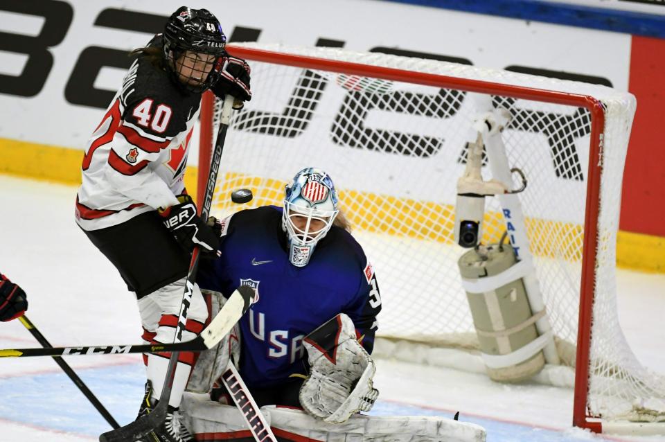 Goalie Alex Rigsby of USA and Blayre Turnbull of Canada, left, in action during the 2019 IIHF Women's World Championships preliminary match between USA and Canada in Espoo, Finland, Saturday April 6, 2019. (Antti Aimo-Koivisto/Lehtikuva via AP)