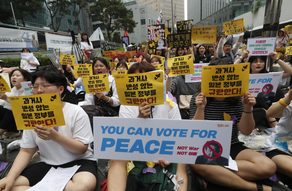 Protesters shout slogans during a rally demanding full compensation and an apology for wartime sex slaves from Japanese government in front of the Japanese Embassy in Seoul, Wednesday, July 17, 2019. In his strongest comments yet on a growing trade dispute, South Korean President Moon Jae-in urged Japan on Monday to lift recently tightened controls on high-tech exports to South Korea, which he said threaten to shatter the countries' economic cooperation and could damage Japan more than South Korea. The signs read: "Apology and compensation." (AP Photo/Ahn Young-joon)