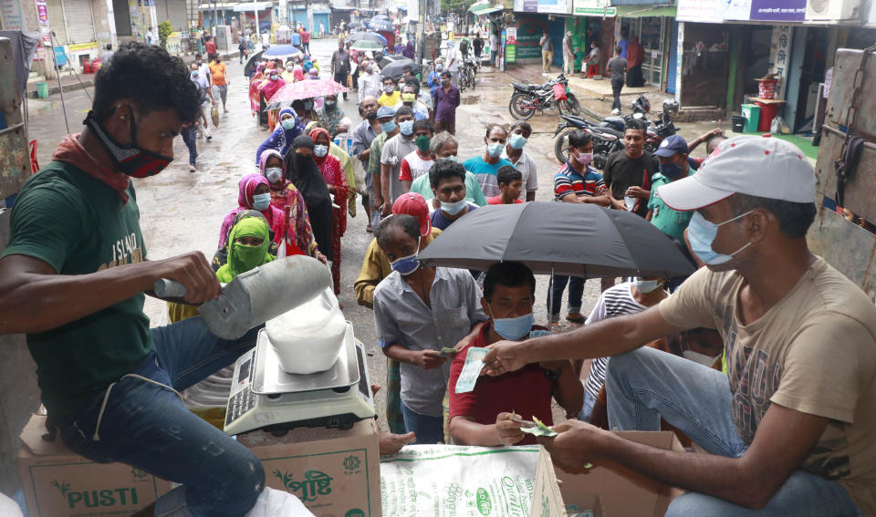 People line up to receive ration without maintaining social distancing in Rajshahi, 254 kilometers (158 miles) north of the capital, Dhaka, Bangladesh, June 16, 2021. Rajshahi has become one of the latest hotspots for the deadlier delta variant of the coronavirus. Bangladeshi authorities are increasingly becoming worried over the quick spread of coronavirus in about two dozen border districts close to India amid concern that the virus could devastate the crowded nation in coming weeks. (AP Photo/ Kabir Tuhin)
