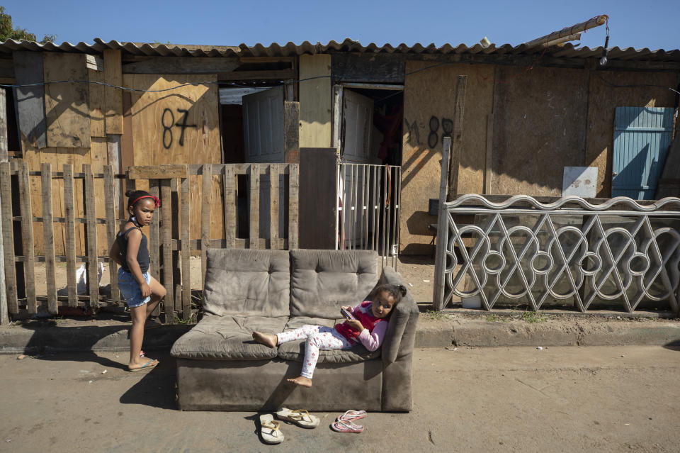 Children play outside their shack home in the Jardim Julieta squatter camp in Sao Paulo, Brazil, Thursday, July 23, 2020. The coronavirus had just hit the city when this parking lot for trucks became a favela, with dozens of shacks. Since the first wave of residents in mid-March, hundreds of families joined, with most having been evicted during the pandemic. (AP Photo/Andre Penner)