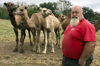 In this Oct. 7, 2019 photo, Scott Allen, who runs Pettit Creek Farms in bone-dry Bartow County, Ga., poses for a photo. Allen says the small streams normally used to provide water for his camels, kangaroos, zebras and other animals have dried up so they are forced to rely on other water sources. Allen says the animals are fine, but the dust is relentless since there's been no significant rain during the past two months. (AP Photo/Jeff Martin) (AP Photo/Jeff Martin)