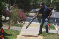 Antonio Espinoza, a supervisor with the Gras Lawn landscaping company, uses a gasoline-powered leaf blower to clean up around a housing development in Brick, N.J. on June 18, 2024. New Jersey is one of many states either considering or already having banned gasoline-powered leaf blowers on environmental and health grounds, but the landscaping industry says the battery-powered devices favored by environmentalists and some governments are costlier and less effective than the ones they currently use. (AP Photo/Wayne Parry)