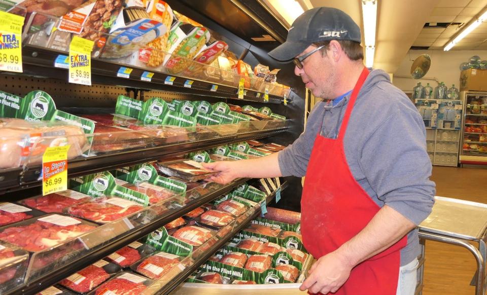 Dana Bayes restocks Agridime cuts of beef at Barnes Heartland Foods in Herington, Kansas.