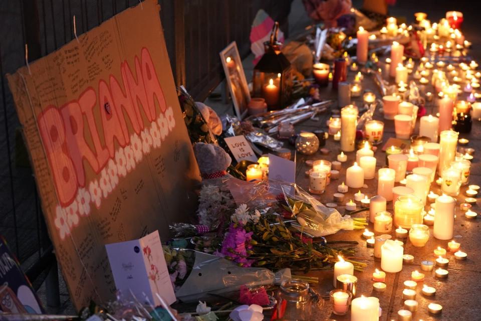 Flowers and candles are left during a candlelit vigil at Old Market Place in Warrington, in memory of Brianna (PA)