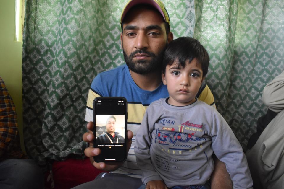 Firdous Ahmad, brother of slain civilian (Manzoor Ahmad, who was killed in Sopore attack) on Saturday, along with the son of Manzoor Ahmad, showing the photograph of his brother (Manzoor Ahmad).