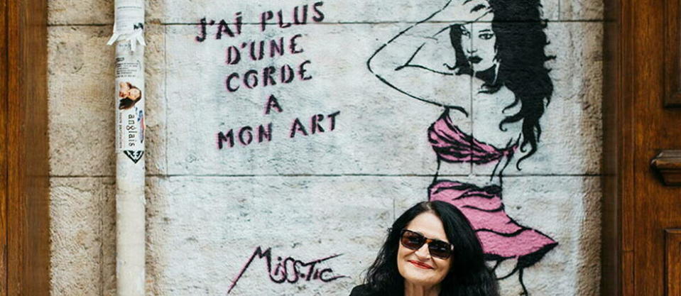 Miss. Tic devant la fresque qu'elle a dessinée sur la façade du café Le Balto, rue Mazarine à Paris.
