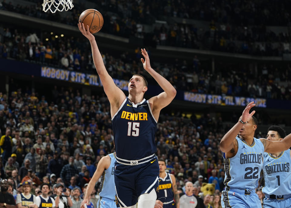 Denver Nuggets center Nikola Jokic, left, goes up for a basket past Memphis Grizzlies guard Desmond Bane in the first half of an NBA basketball game, Monday, March 25, 2024, in Denver. (AP Photo/David Zalubowski)