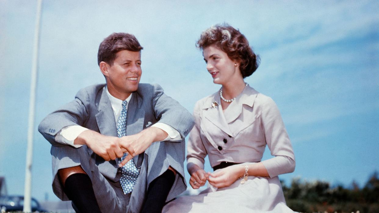 John F. Kennedy and Jacqueline Bouvier sit together in the sunshine at Kennedy's family home at Hyannis Port, Massachusetts, a few months before their wedding.