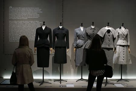 Visitors look at vintage dresses by designers Balenciaga, Christian Dior, Pierre Cardin and Jacques Fath presented in the exhibition "Les Annees 50, La mode en France" (The 50s. Fashion in France, 1947-1957) at the Palais Galliera fashion museum in Paris, July 10, 2014. REUTERS/Benoit Tessier