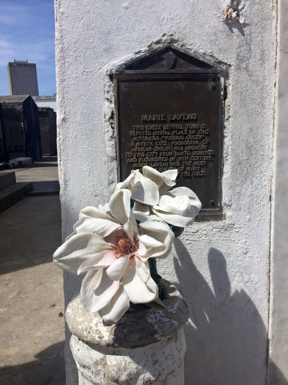 This June 3, 2018 photo shows an offering and plaque marking the tomb for Marie Laveau at St. Louis Cemetery No. 1 in New Orleans. The marker calls her the "notorious voodoo queen ... the most widely known of many practitioners of the cult." She died in 1881. (AP Photo/Beth J. Harpaz)