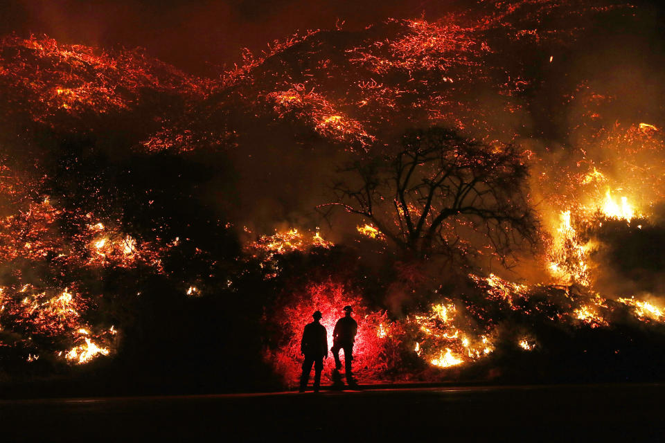 <p>Firefighters monitor a section of the Thomas Fire along the 101 freeway on December 7 north of Ventura, California.</p>