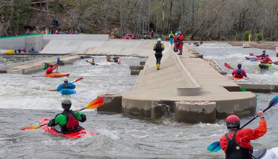 More than a dozen kayakers paddle the “paperclip” at the long bypass on the Catawba River in Great Falls, S.C.
