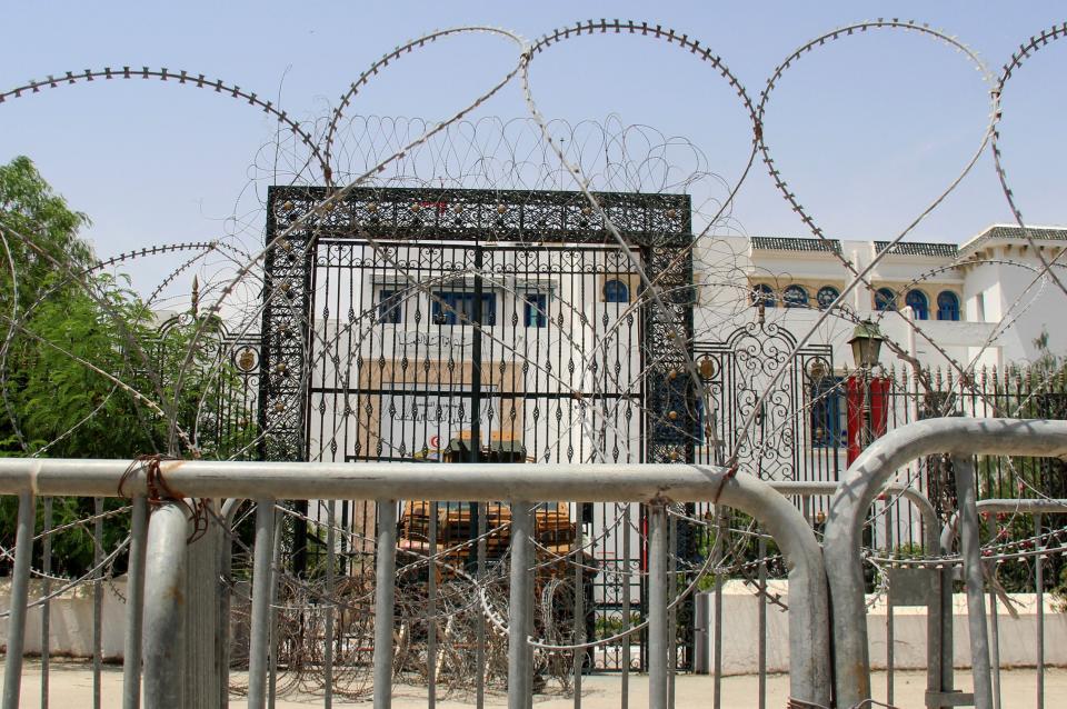 Barbed wire and a military armored personnel carrier block a side entrance of the Tunisian parliament (AP)