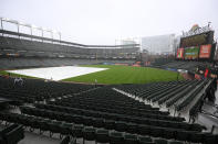 The tarp lies on the field during a weather delay before a baseball game between the Baltimore Orioles and the Kansas City Royals, Wednesday, April 3, 2024, in Baltimore. (AP Photo/Nick Wass)