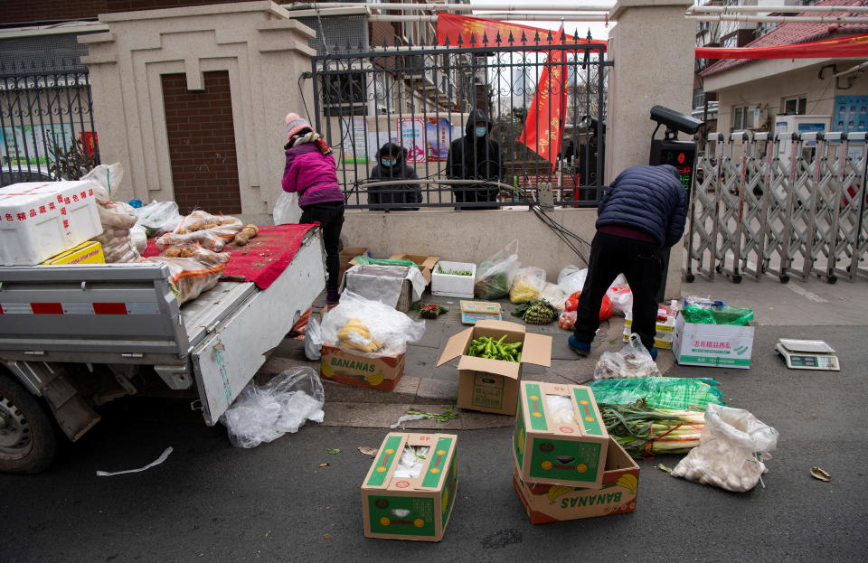 Grocery vendors sell vegetables outside a residential compound which has been blocked off by authorities amid an outbreak of COVID-19 in Shijiazhuang, Hebei province, China, January 19, 2021. / Credit: STRINGER/Reuters