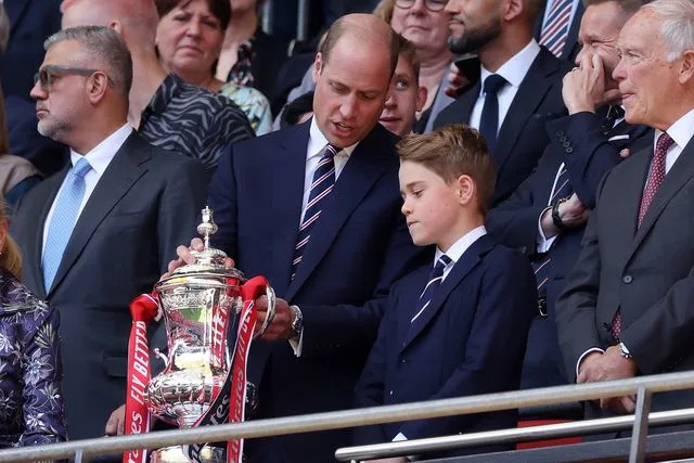 <p>Eddie Keogh - The FA/The FA via Getty</p> Prince William and Prince George look at the Emirates FA Cup Trophy after the Emirates FA Cup Final