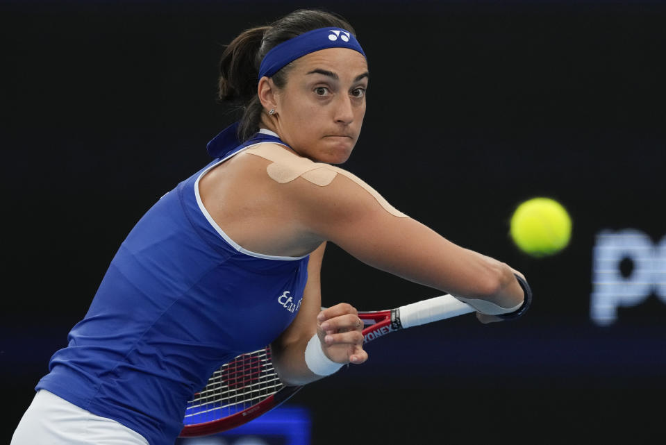 Caroline Garcia of France plays a backhand return to Poland's Iga Swiatek during their United Cup semifinal tennis match in Sydney, Australia, Saturday, Jan. 6, 2024. (AP Photo/Mark Baker)