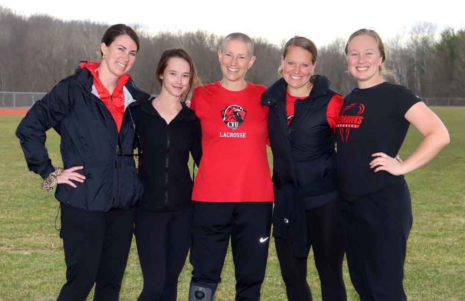 Champlain Valley Union High School coach Tucker Pierson, center in red, poses for a photo with her assistant girls lacrosse coaches in spring 2023.