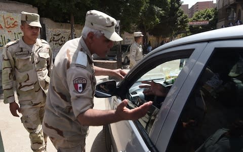 Egyptian soldiers check a car amid heightened security during the presidential elections - Credit: AFP