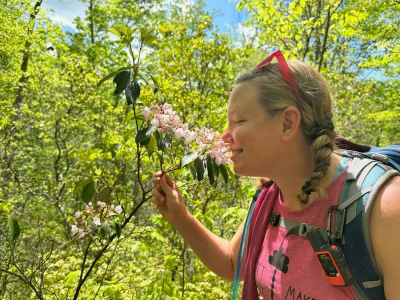 Ashley Walker celebrates spring smelling wild mountain flowers on Sugarland Mountain Trail May 9, 2023.