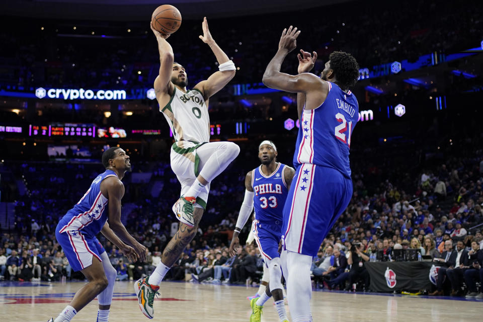 Boston Celtics' Jayson Tatum (0) goes up for a shot against Philadelphia 76ers' Joel Embiid (21) during the second half of an NBA basketball game, Wednesday, Nov. 15, 2023, in Philadelphia. (AP Photo/Matt Slocum)