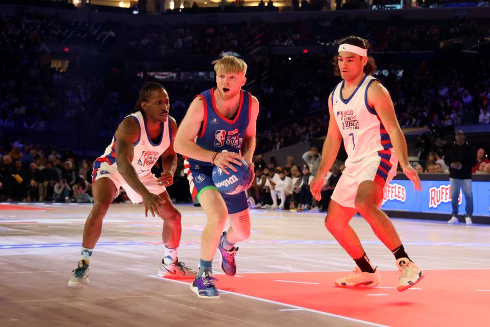 Tristan Jass (22) of Team Stephen A controls the ball against Puka Nacua (17) and Quincy Isaiah (72) of Team Shannon in the first quarter during the All Star Celebrity Game at Lucas Oil Stadium.