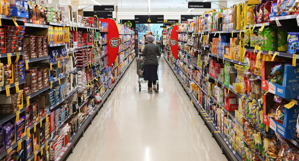 A woman walks down an aisle at a shopping centre.