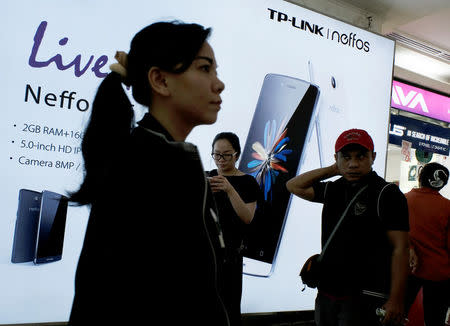 Shoppers walk near a smartphone advertisement at ITC Roxymas shopping mall in Jakarta, Indonesia, September 22, 2016. REUTERS/Beawiharta