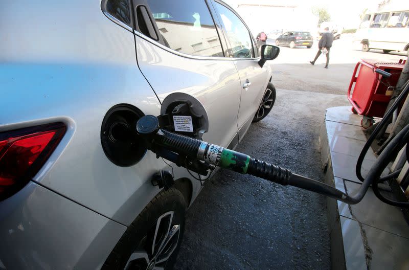 FILE PHOTO: A car is being filled with fuel at a gas station in Algiers
