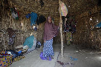 Husseina Ali, 9, daughter of Aisha Ali, stands inside the hut where she found refuge from the floods in Darayami, northeastern Nigeria, Wednesday Oct. 26, 2022. When floodwaters reached her hut made of woven straw mats and raffia palms, Aisha packed up what belongings she could and set off on foot with her eight youngest children. "While the flood was trying to destroy things, we were trying to save ourselves," she said. Four of her children perished. (AP Photo/Sunday Alamba))