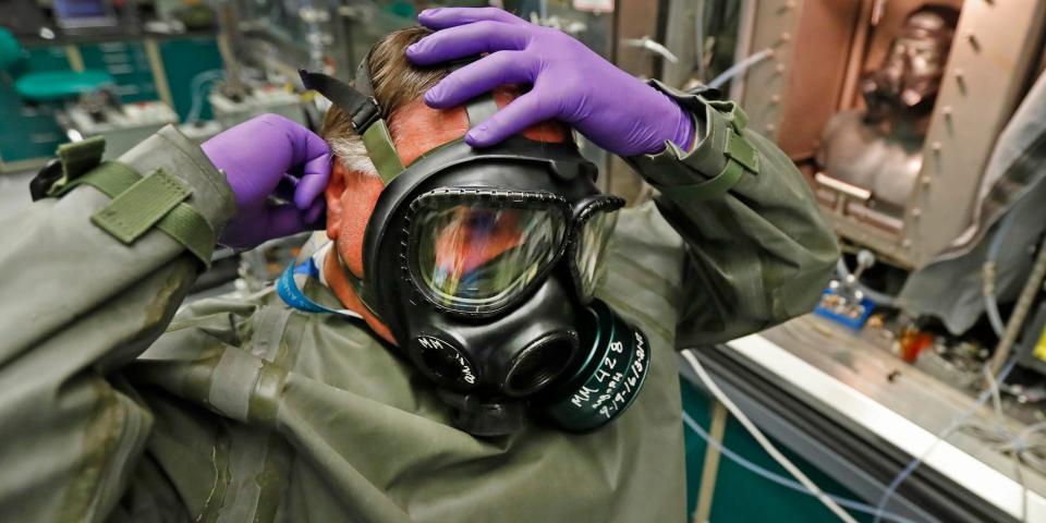 A technician puts on a gas mask as he prepares for a chemical test in Dugway Proving Ground in 2017.