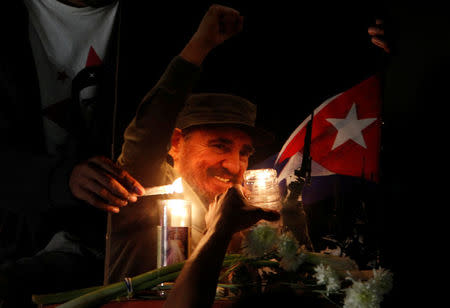 People place candles beside a picture of Fidel, as part of a tribute, following the announcement of the death of Cuban revolutionary leader Fidel Castro, in Tegucigalpa, Honduras November 26, 2016. REUTERS/Jorge Cabrera