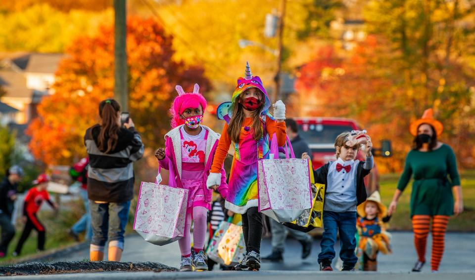 Lilah Gibson, center, Zion Hart, left in pink, Parker Stevens, right in bowtie, and Presley Stevens, right as scarecrow, head up to Perry Township Volunteer Fire Department to get some candy and treats from the firefighters there during safe Trick-or-Treating at local fire departments Saturday, October 31, 2020.