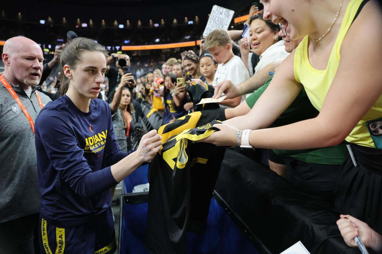 LAS VEGAS, NEVADA - JULY 02: Caitlin Clark #22 of the Indiana Fever signs autographs for fans before a game against the Las Vegas Aces at T-Mobile Arena on July 02, 2024 in Las Vegas, Nevada. NOTE TO USER: User expressly acknowledges and agrees that, by downloading and or using this photograph, User is consenting to the terms and conditions of the Getty Images License Agreement. (Photo by Ethan Miller/Getty Images)