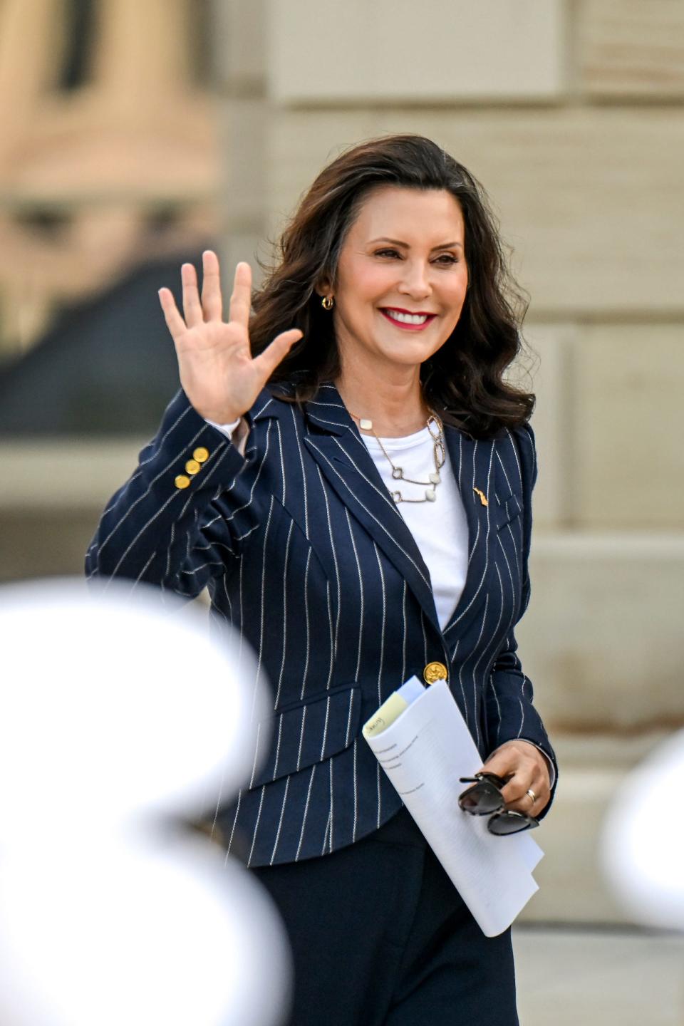 Gov. Gretchen Whitmer waves to the crowd at an event to announce the naming of a new U.S. Navy ship the USS Lansing on Monday, July 22, 2024, outside the Capitol in Lansing.