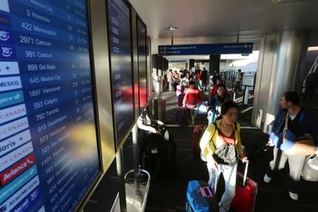 Travelers pass through Los Angeles International Airport (LAX) on the day before Thanksgiving in Los Angeles