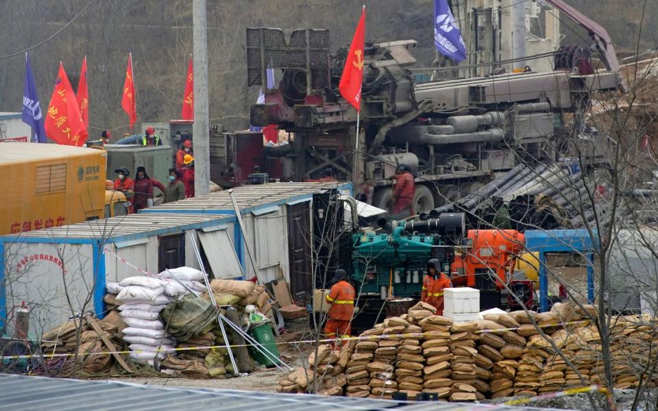 Rescuers work at the Hushan gold mine where workers were trapped underground after the explosion in Qixia - Reuters