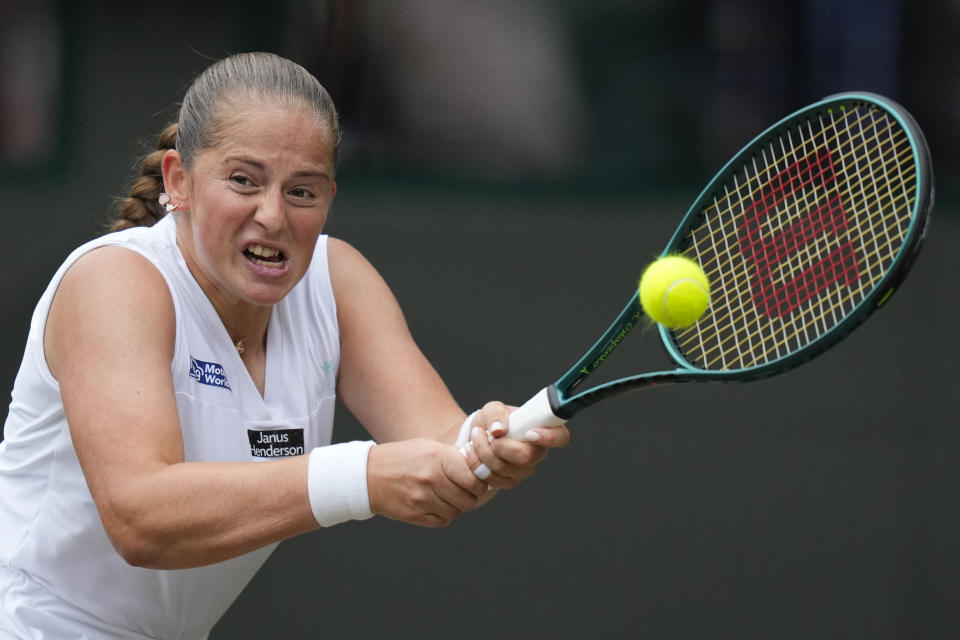 Jelena Ostapenko of Latvia plays a backhand return to Barbora Krejcikova of the Czech Republic during their quarterfinal match at the Wimbledon tennis championships in London, Wednesday, July 10, 2024. (AP Photo/Mosa'ab Elshamy)