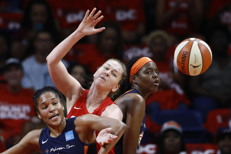 From left to right, Connecticut Sun forward Alyssa Thomas, Washington Mystics center Emma Meesseman and Sun forward Jonquel Jones become entangled while going for the ball in the first half of Game 1 of basketball's WNBA Finals, Sunday, Sept. 29, 2019, in Washington. (AP Photo/Patrick Semansky)