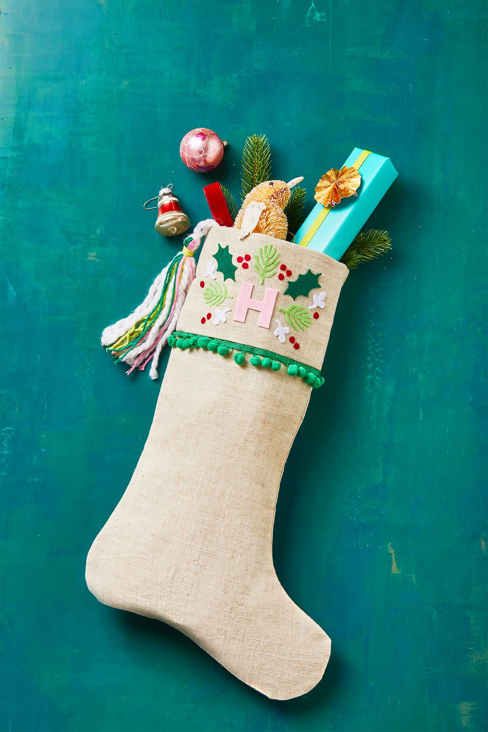 <p>If time is on your side, make a bunch of personalized stockings for your entire family before Christmas morning. To make, fold the hem of the stocking to attach ribbon or pom pom-trim, then decorate with festive stickers and felt cut-outs. Once it's fully dry, fill it with an assortment of stocking stuffers. </p>