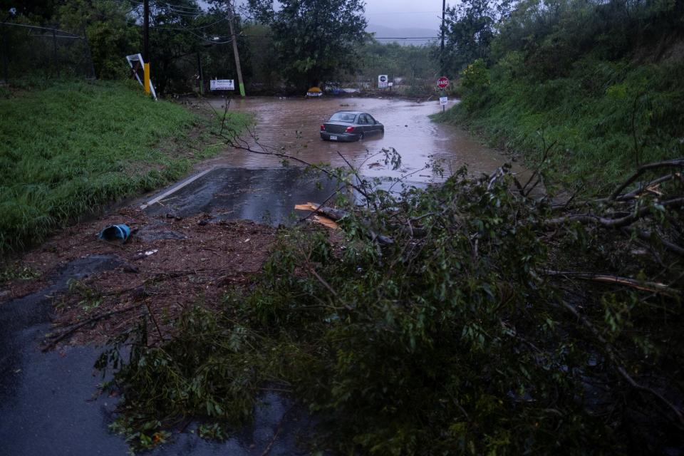 A car sits in flood waters after Hurricane Fiona affected the area in Yauco, Puerto Rico, 18 September 2022 (Reuters)