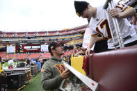 Washington Commanders quarterback Taylor Heinicke (4) signs autographs for a fan before the start of an NFL football game against the Minnesota Vikings, Sunday, Nov. 6, 2022, in Landover, Md. (AP Photo/Nick Wass)