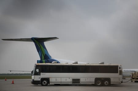 FILE PHOTO - Transport buses used to carry migrants in U.S. Immigration and Customs Enforcement (ICE) custody are seen parked next to chartered planes before departure from Brownsville South Padre International Airport in Brownsville
