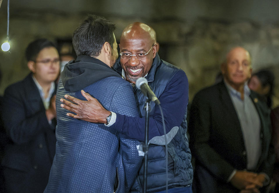 Composer Lin-Manuel Miranda, left, and Georgia incumbent Democratic Sen. Raphael Warnock embrace at a Latino voter rally on Atlanta on Wednesday, Oct 19, 2021. Miranda is one of a number of celebrities trying to sway voters, although it’s unclear how much influence they have. (Arvin Temkar/Atlanta Journal-Constitution via AP)