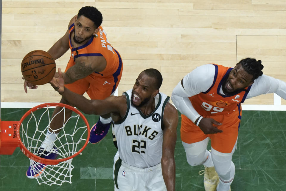 Milwaukee Bucks forward Khris Middleton (22) drives to the basket against Phoenix Suns guard Cameron Payne, left, and Jae Crowder, right, during Game 4 of basketball's NBA Finals in Milwaukee, Wednesday, July 14, 2021. (AP Photo/Paul Sancya, Pool)