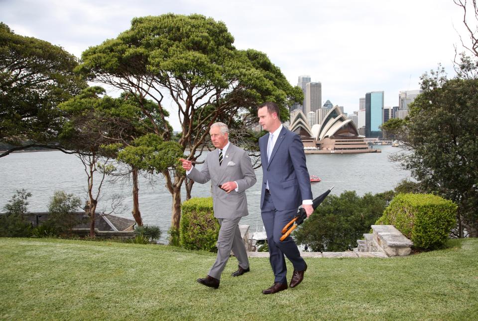 Britain's Prince Charles (L) walks along with with Paul Singer, Director of Operations for Government House, with the Sydney Opera House in the back as he arrives for a Sustainability Leadership Roundtable at Admiralty House in Sydney on November 12, 2015. 12, 2015.  Prince Charles and his wife Camilla are on a two-week tour of New Zealand and Australia.  AFP PHOTO / POOL        (Photo credit should read RICK RYCROFT/AFP via Getty Images)